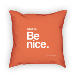 Orange throw pillow with "Be nice" and paw print motif.