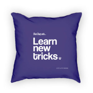 Purple pillow with "Learn new tricks" text, dog theme.