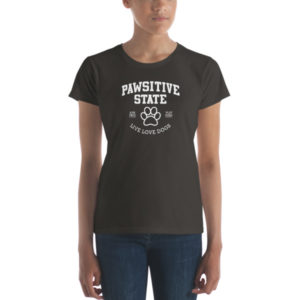 Woman wearing black "Pawsitive State" T-shirt featuring a paw print design.